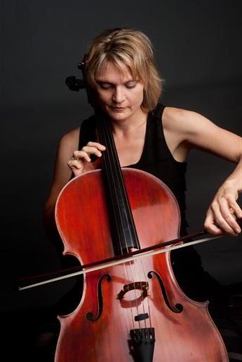 安妮·勒纳-赖特在一个毫无特色的背景下演奏大提琴的照片. 