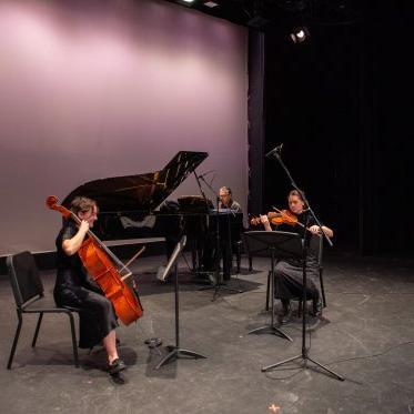 Two musicians, both playing string instruments, 在钢琴家的伴奏下在勒费弗剧院的舞台上表演