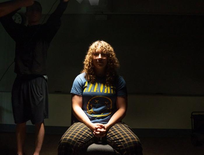 A student sitting under a light in a lighting class